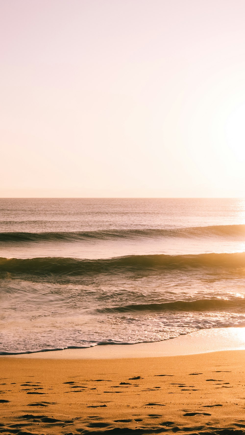 a person riding a surfboard on top of a sandy beach