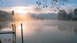 Sunrise over the serene Pokhara lake with mountains in the background.