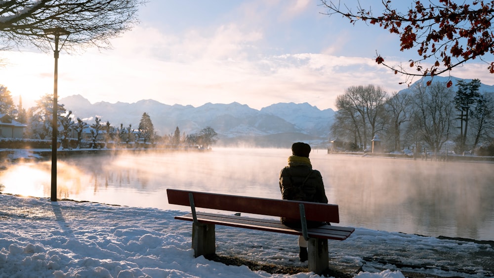 a person sitting on a bench overlooking a lake