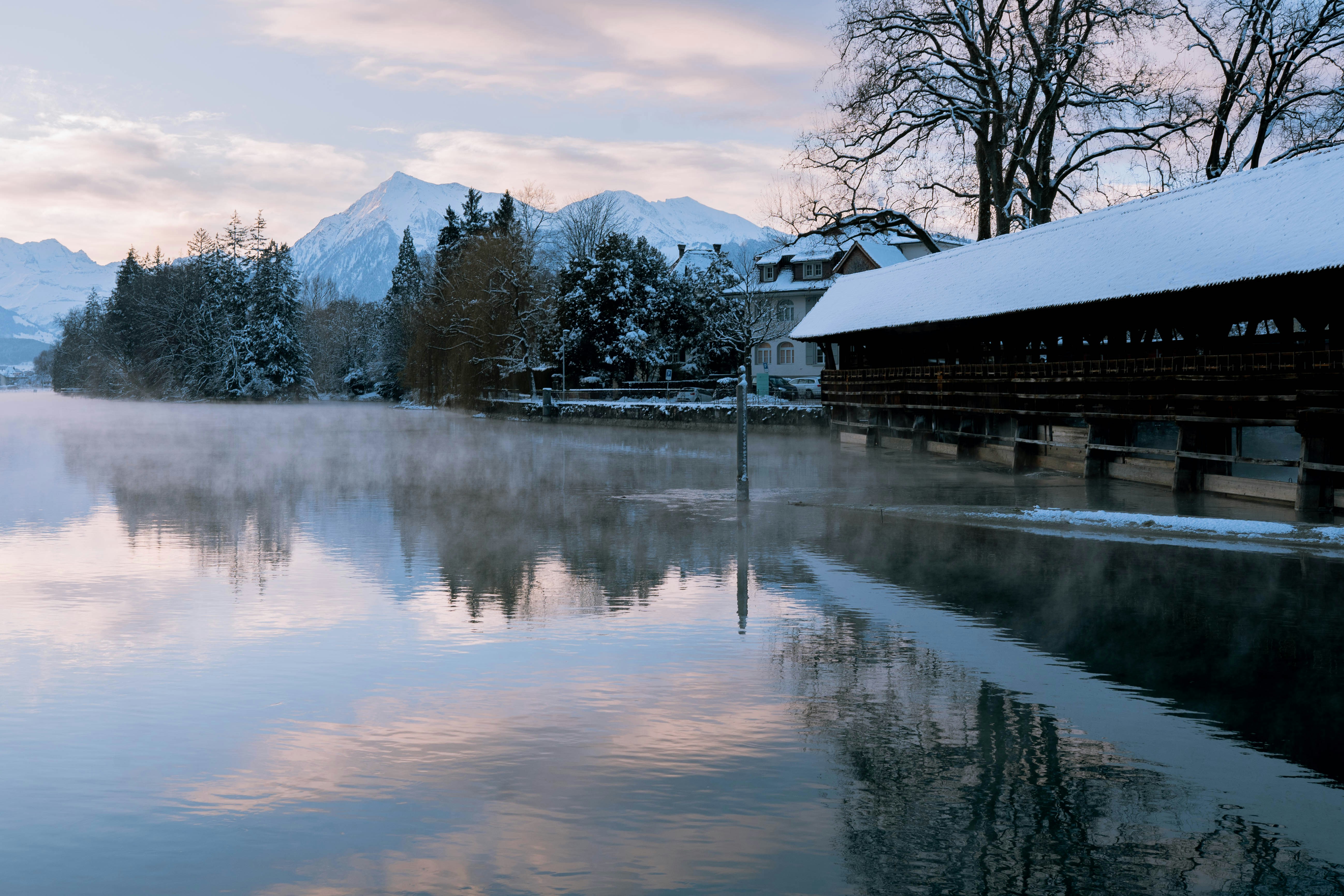a body of water surrounded by snow covered mountains