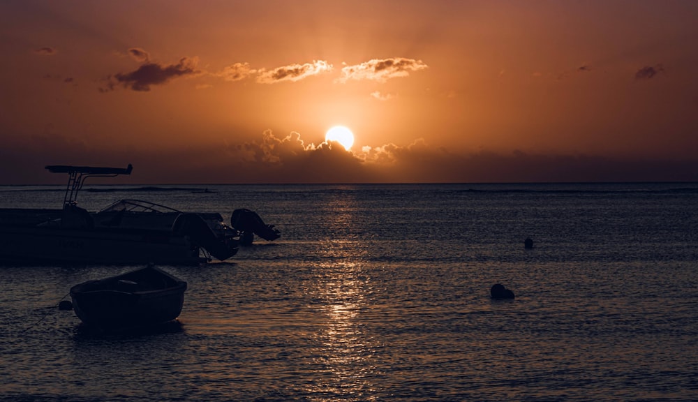 un coucher de soleil sur un plan d’eau avec des bateaux dans l’eau