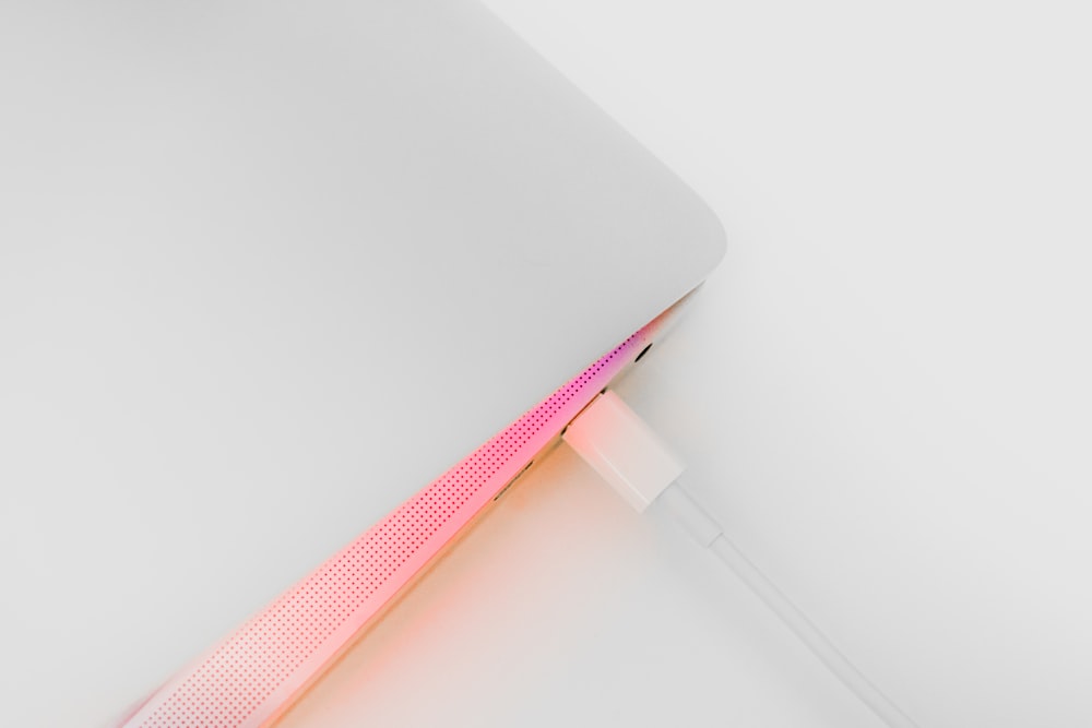a close up of a white surface with a pink light coming out of it