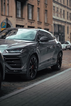 A sleek compact SUV navigating through narrow European city streets with historic buildings in the background.
