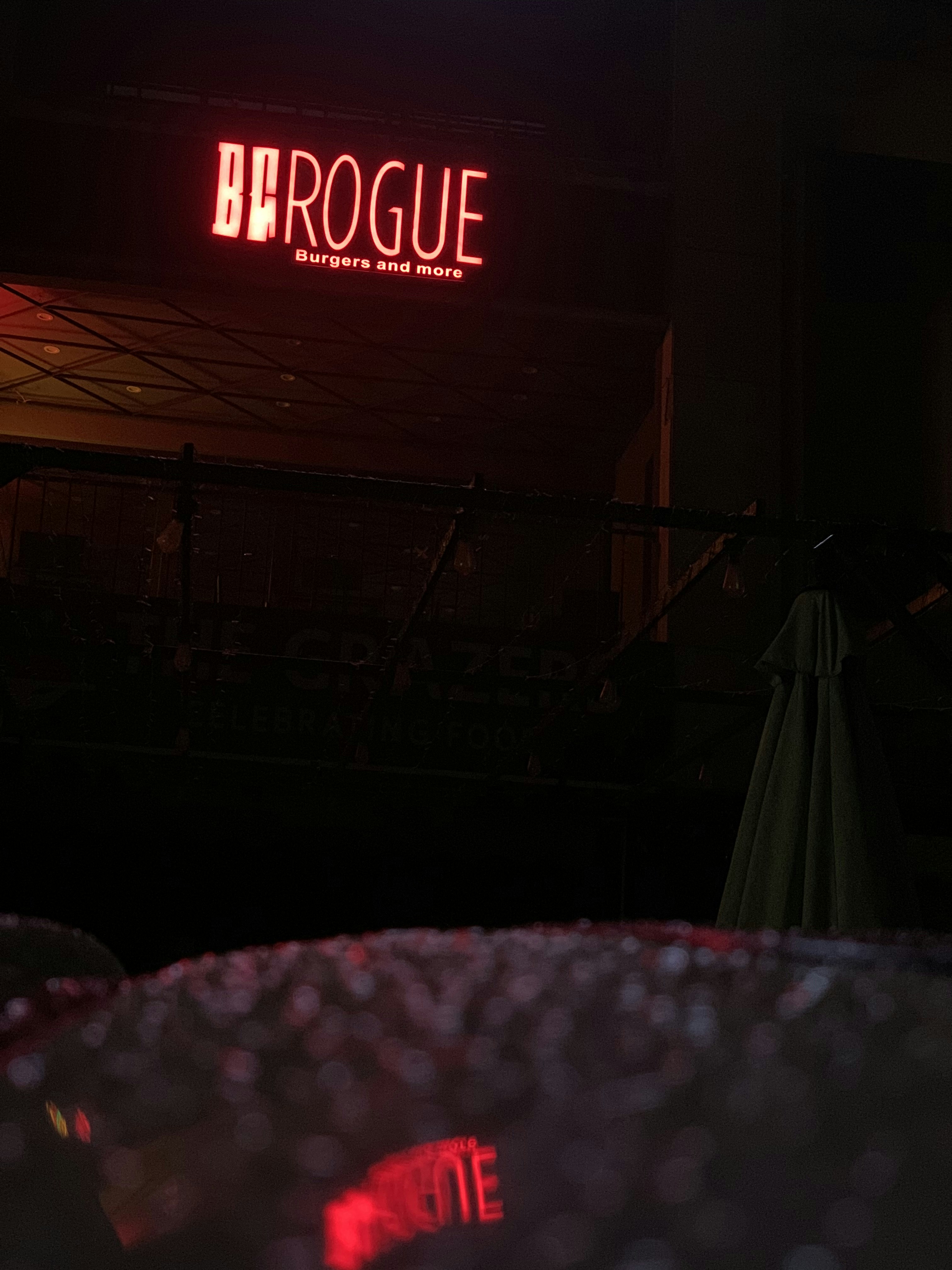 a neon sign that reads broogue in a dark room