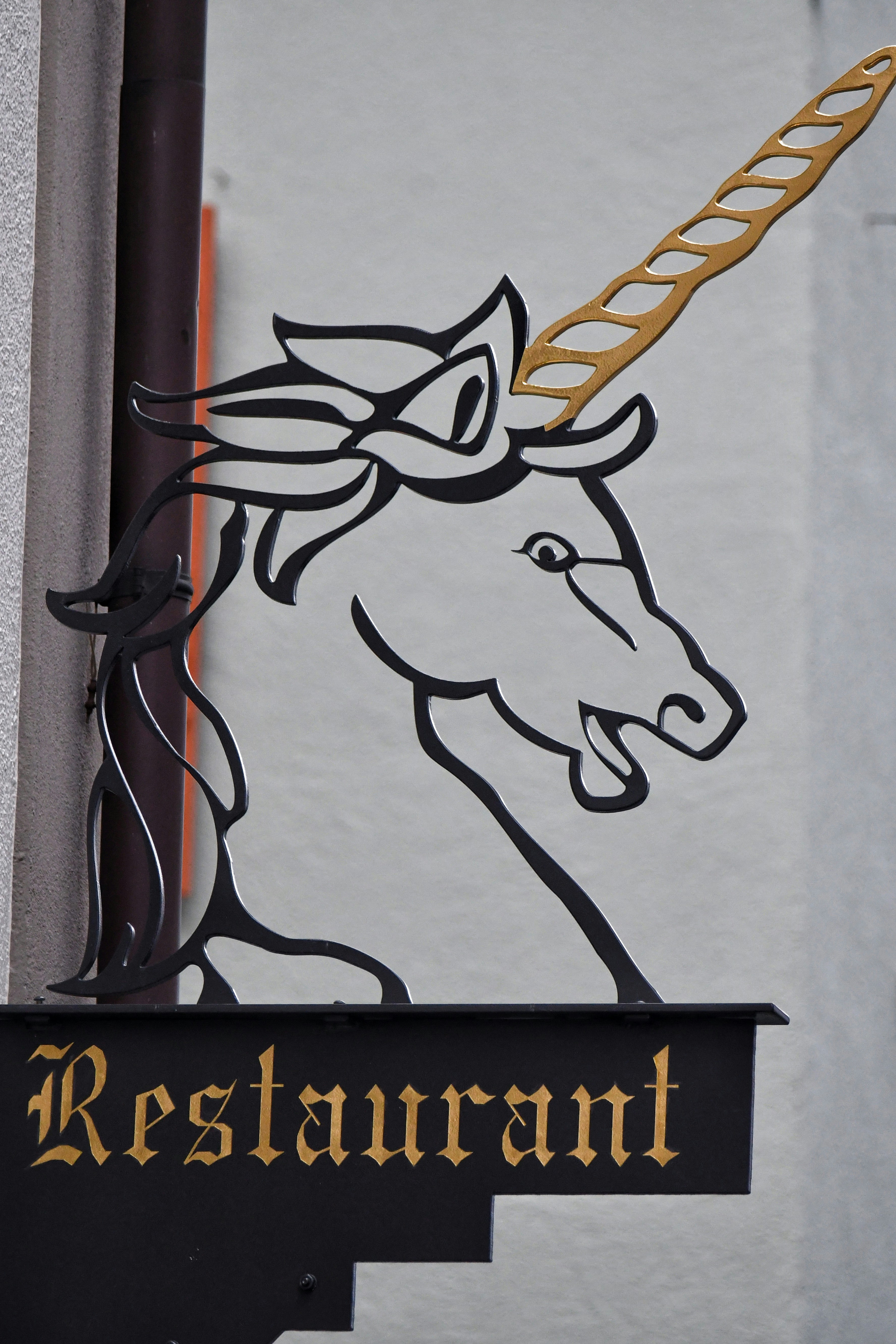 uma placa de restaurante com uma imagem de um unicórnio sobre ele