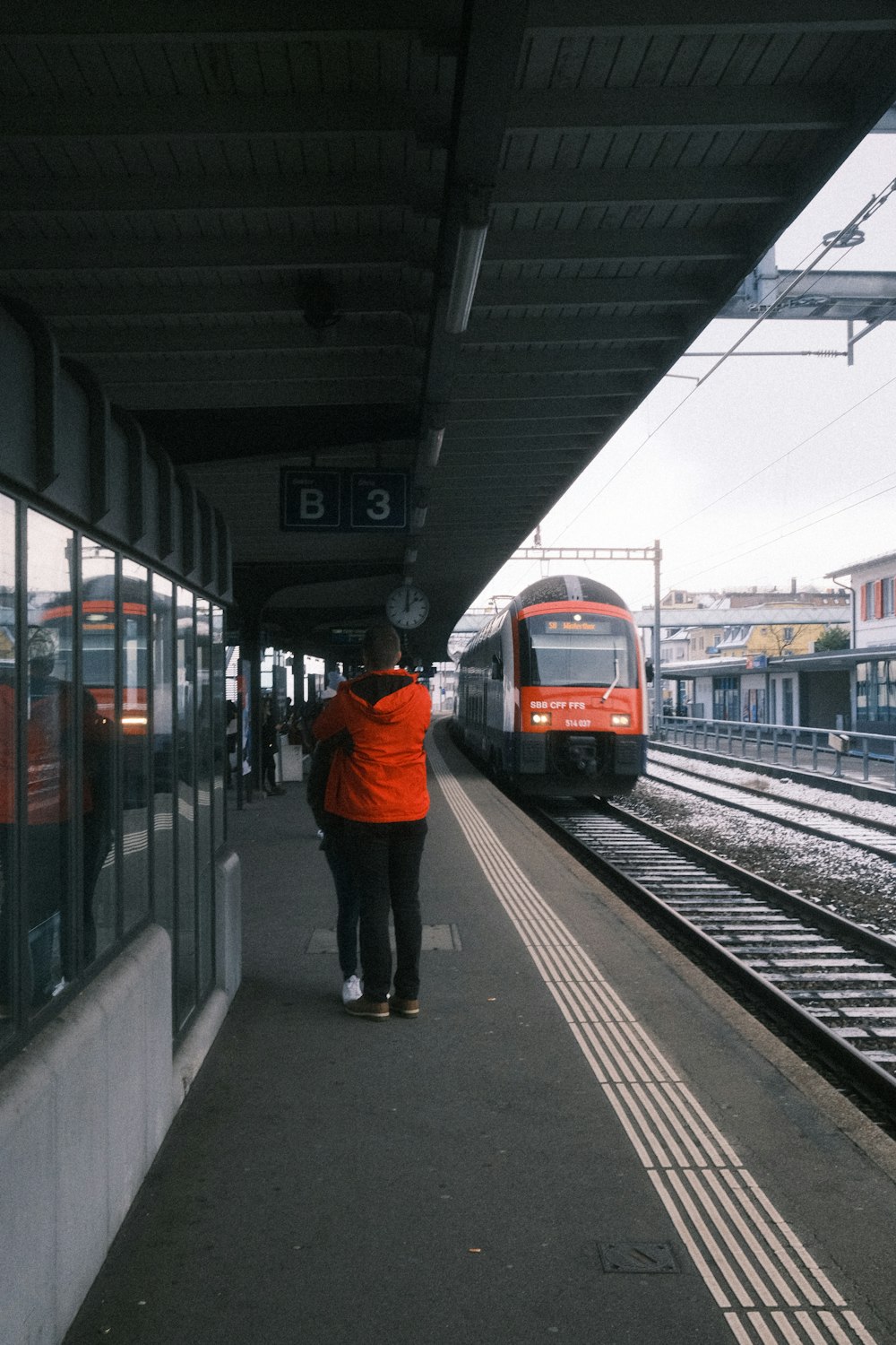a person standing on a train platform near a train