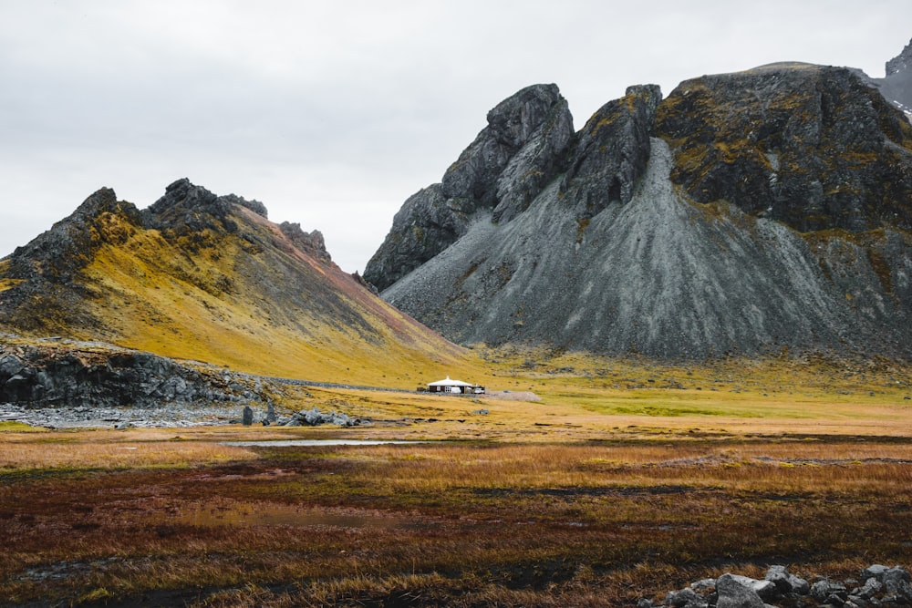 a mountain range with a house in the foreground