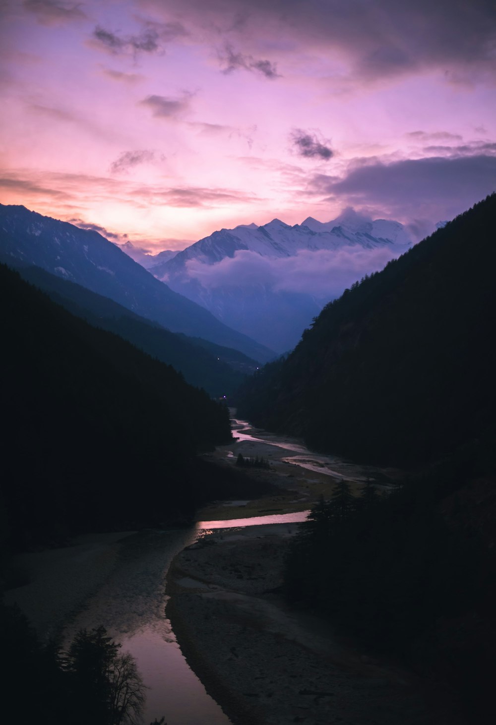 a river running through a valley surrounded by mountains