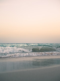 a beach with a wave coming in to shore