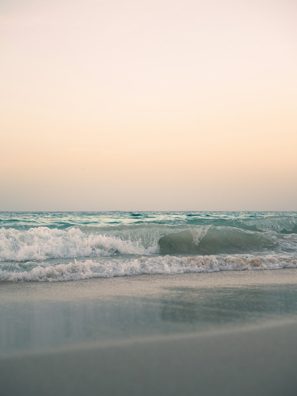 a beach with a wave coming in to shore