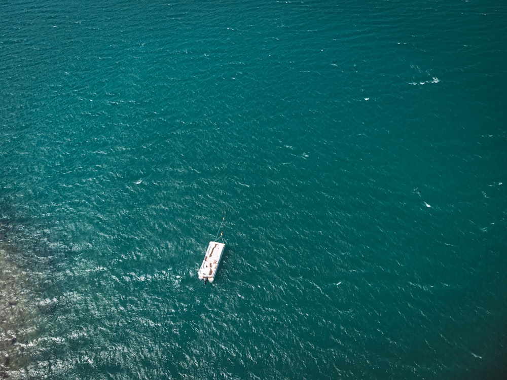 a small boat floating on top of a large body of water