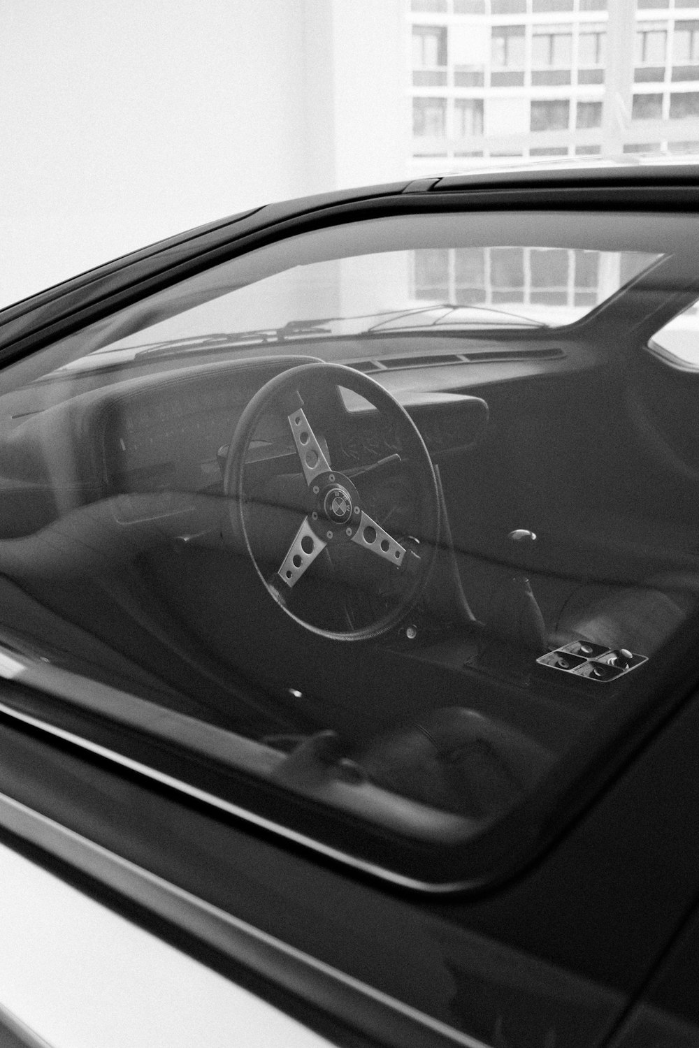 a black and white photo of a car with a steering wheel