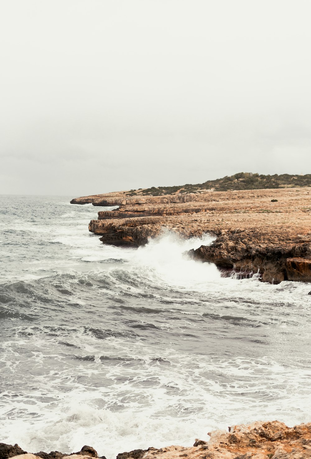 a person standing on a rocky beach next to the ocean