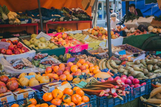 A vibrant market stall filled with fresh fruits and vegetables under a sunny sky