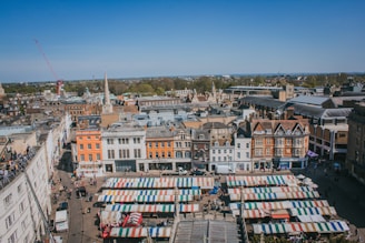 A panoramic view of a historic town square bustling with people and local vendors.