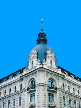 a large white building with a clock on the top of it