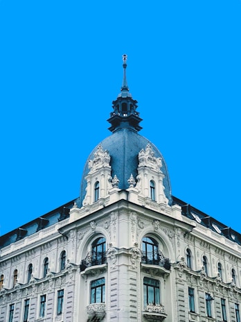 a large white building with a clock on the top of it