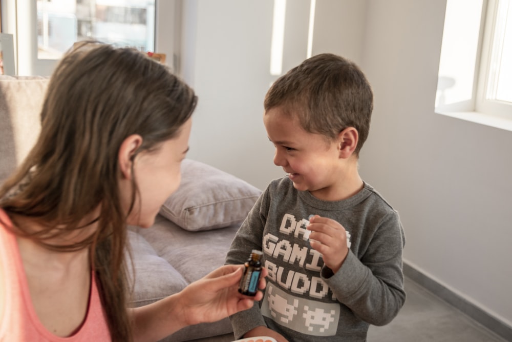 a woman is showing a boy something to eat