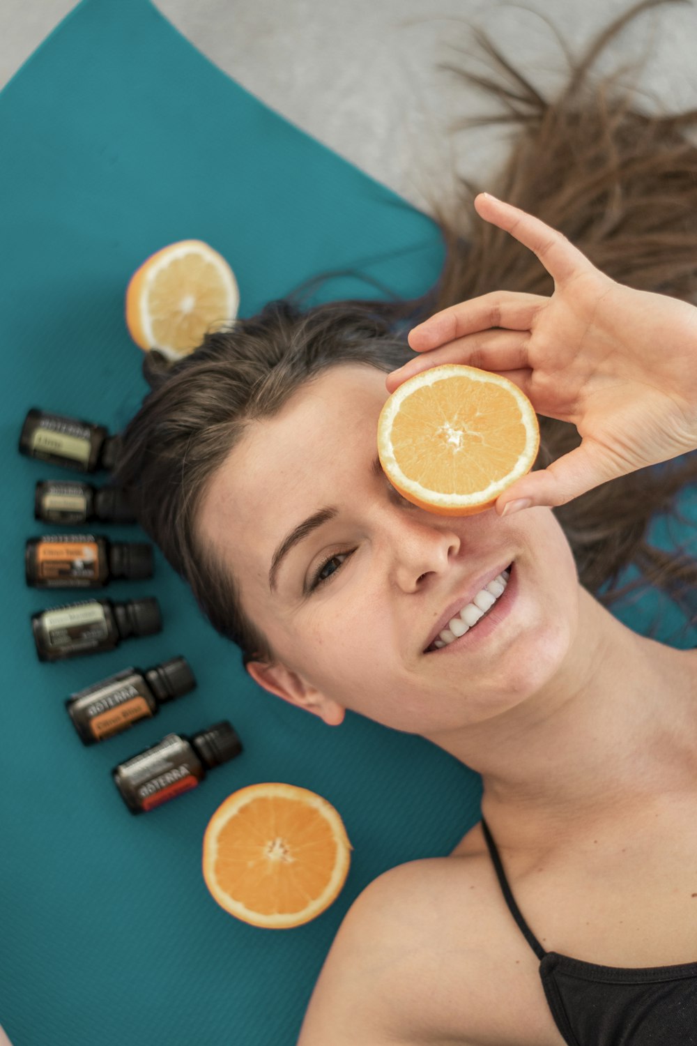 a woman laying on a mat holding an orange