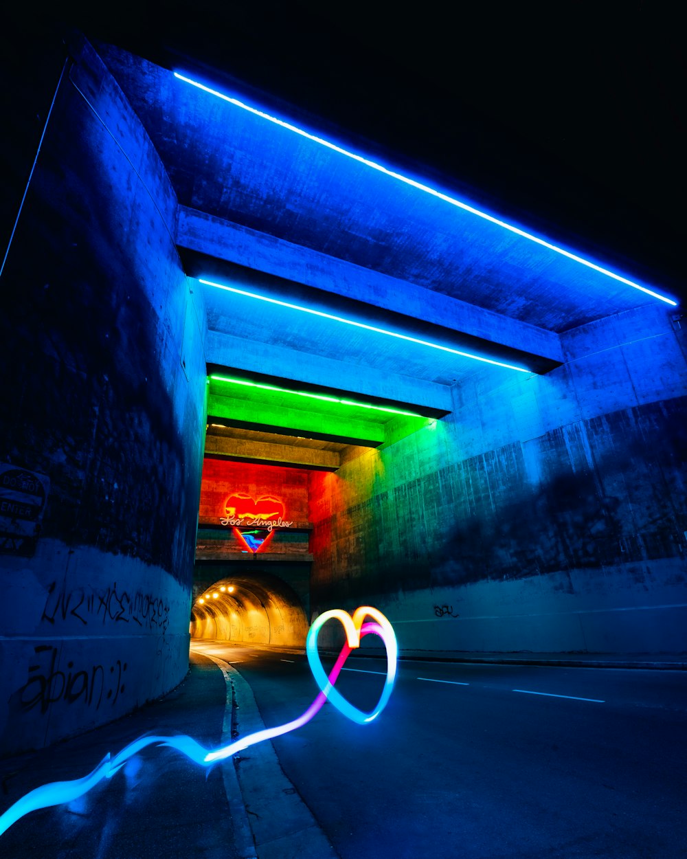 a long exposure photo of a tunnel with a heart painted on it