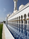 a large white building with a pool in front of it