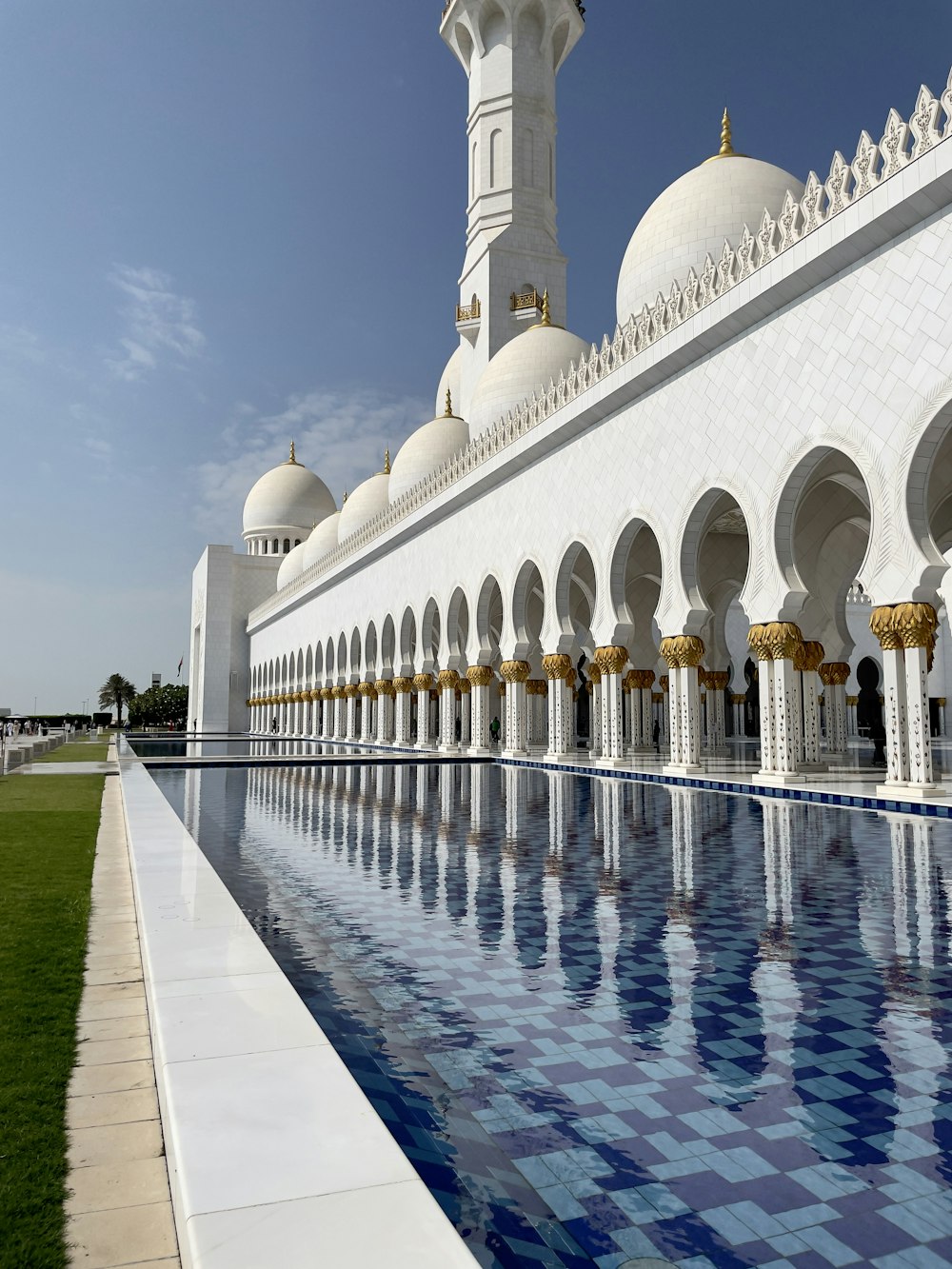 a large white building with a pool in front of it