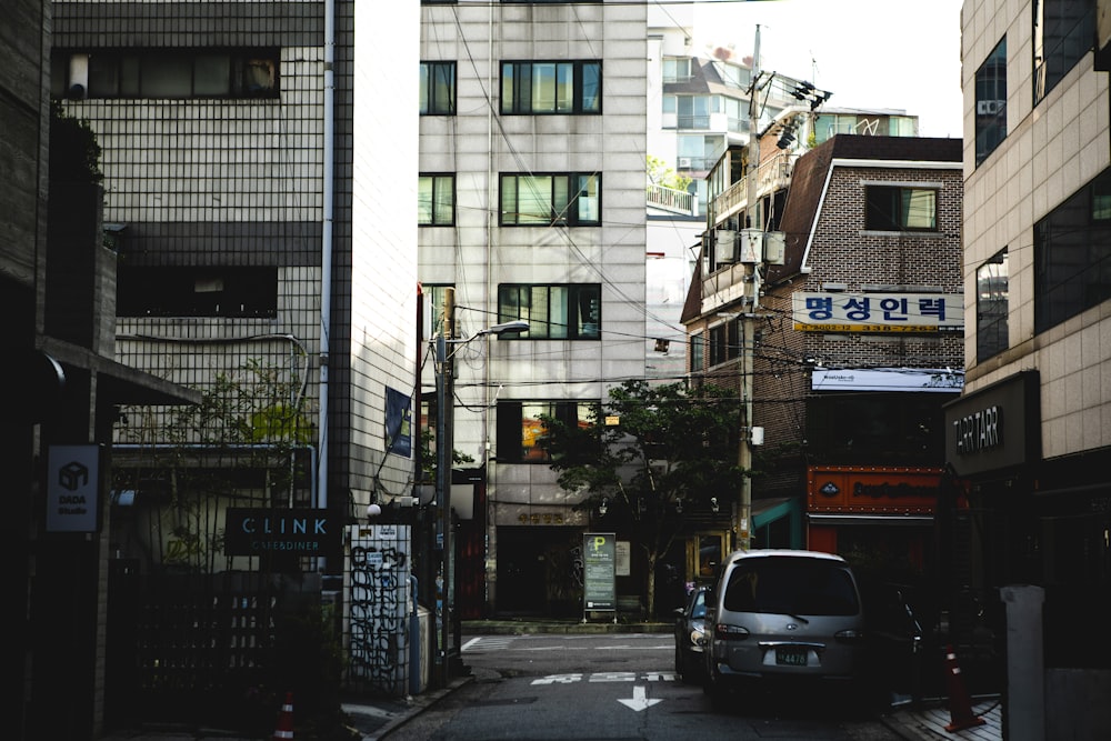 a car driving down a street next to tall buildings