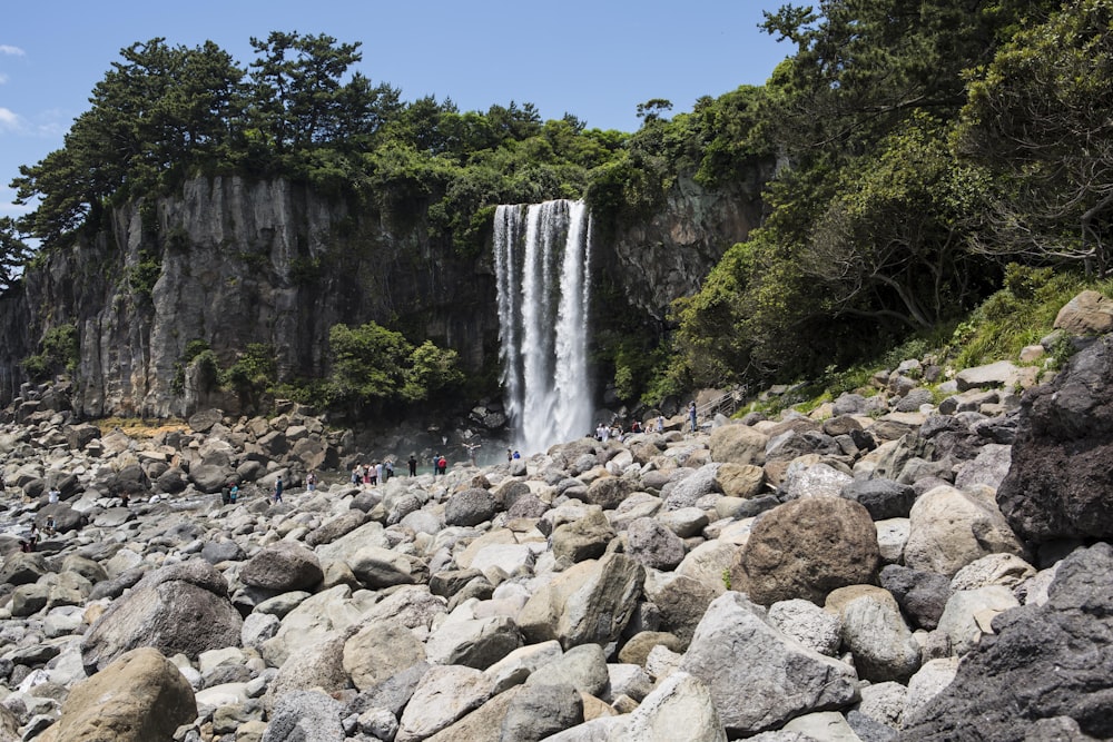 a group of people standing in front of a waterfall