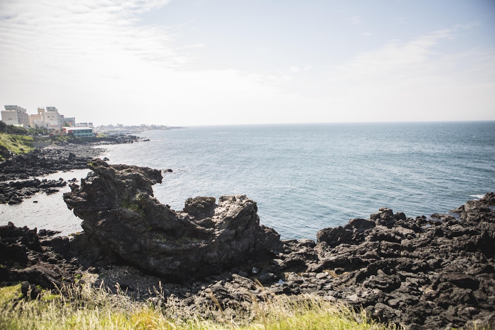 a large body of water sitting next to a lush green hillside