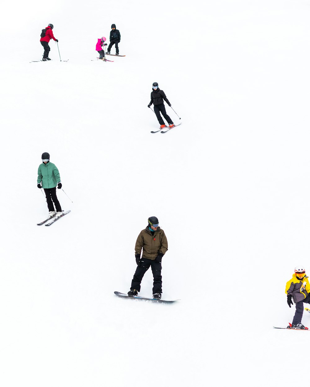 a group of people riding skis down a snow covered slope