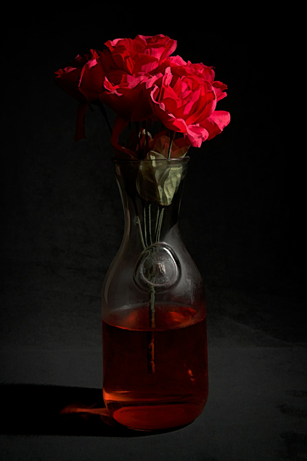 a vase filled with red flowers on top of a table