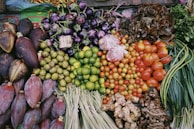 Close-up of ripe, colorful fruits and vegetables neatly stacked at a market stall.