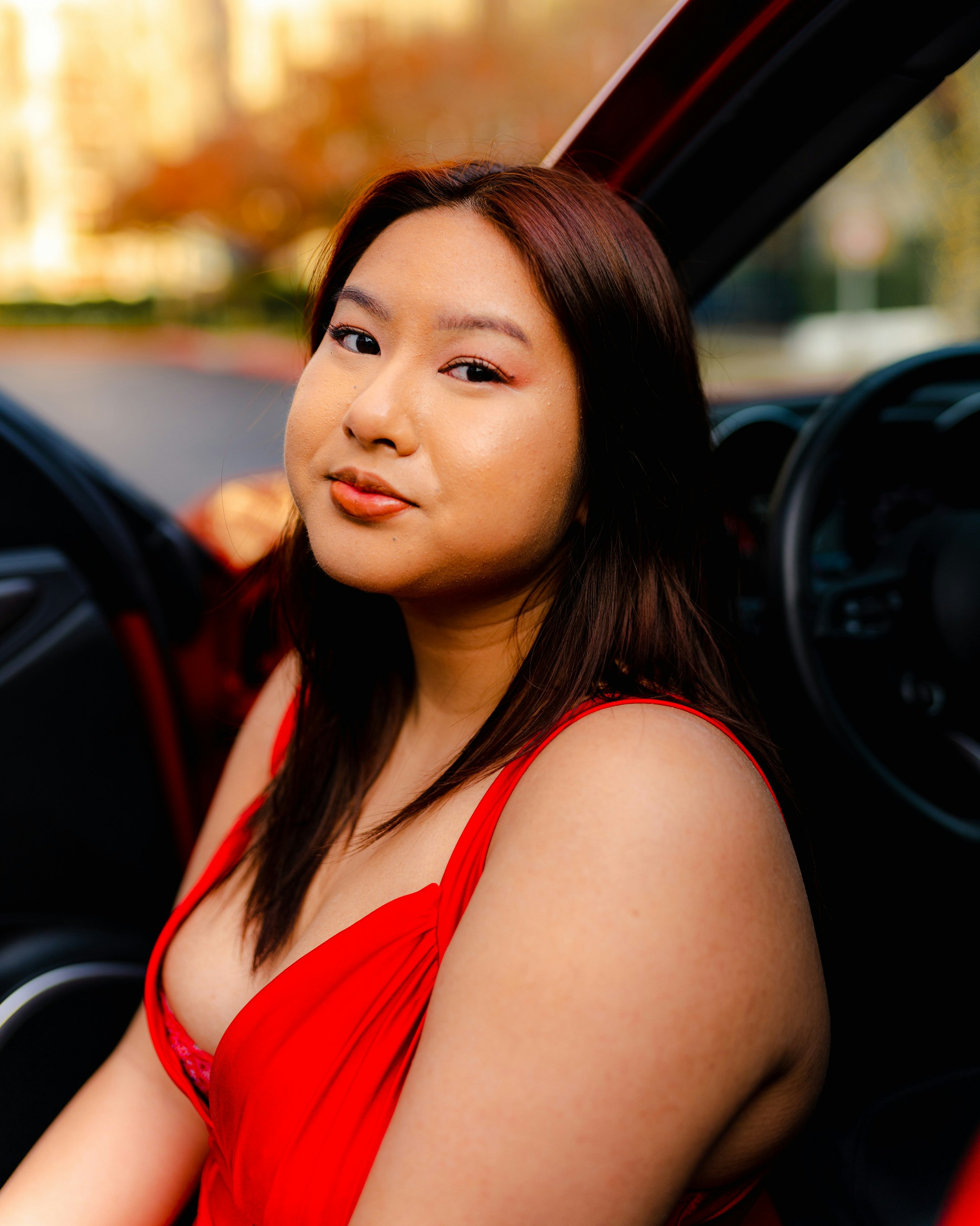 A woman in a red dress sitting in a car photo – Free Woman Image on ...