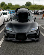 A sleek black roof box mounted on a car ready for a trip