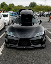 A sleek black roof box mounted on a car ready for a trip