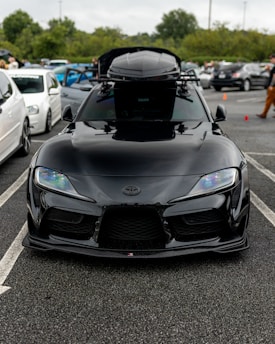 A sleek medium-sized roof box mounted on a family car ready for a holiday trip.