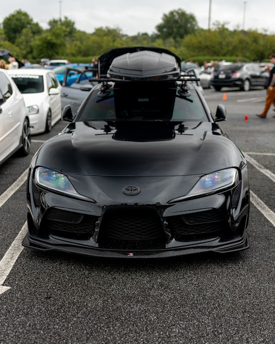 A sleek medium-sized roof box mounted on a family car ready for a holiday trip.
