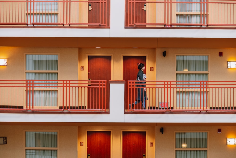 a woman is standing on the balcony of a hotel