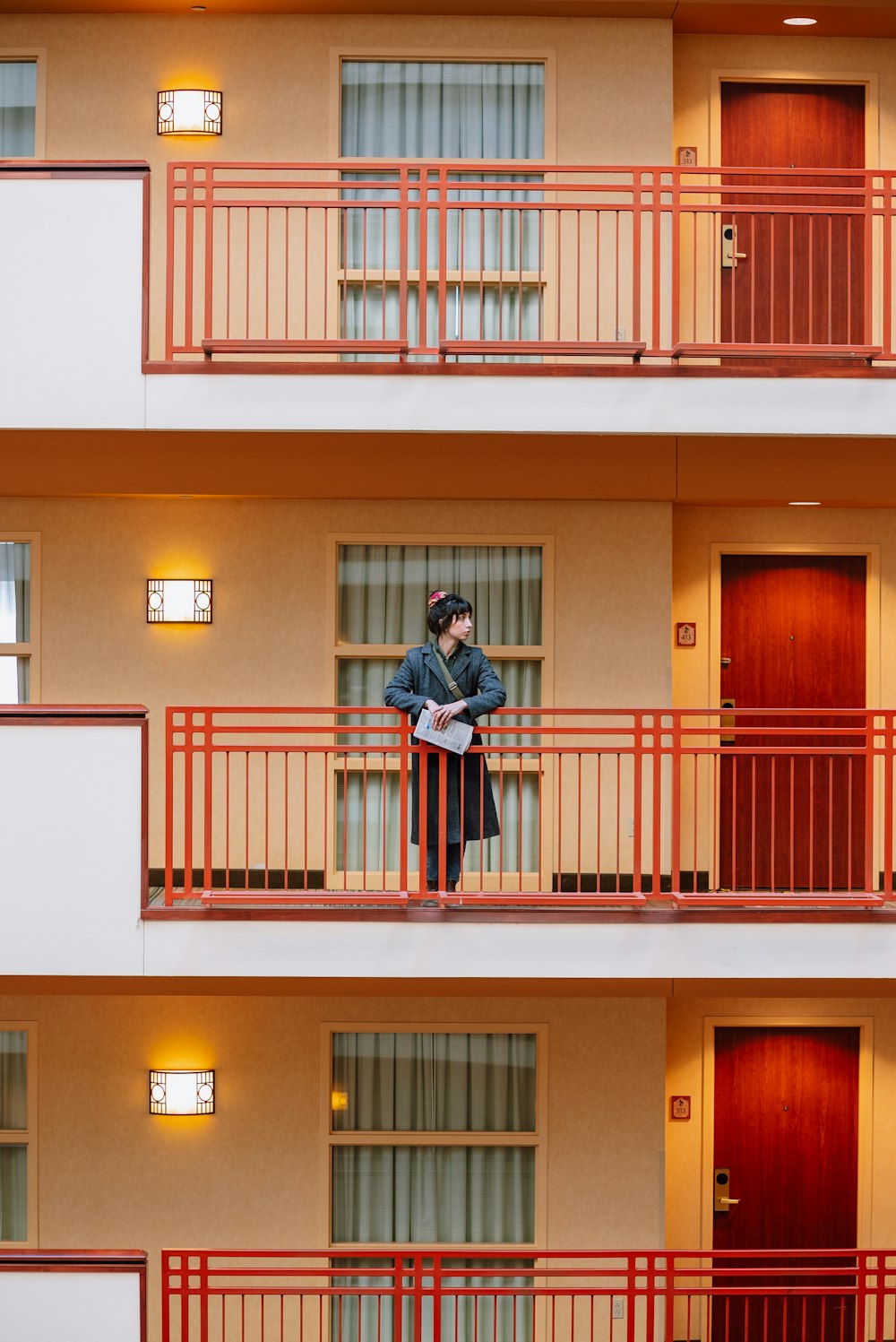 a man standing on a balcony next to a building