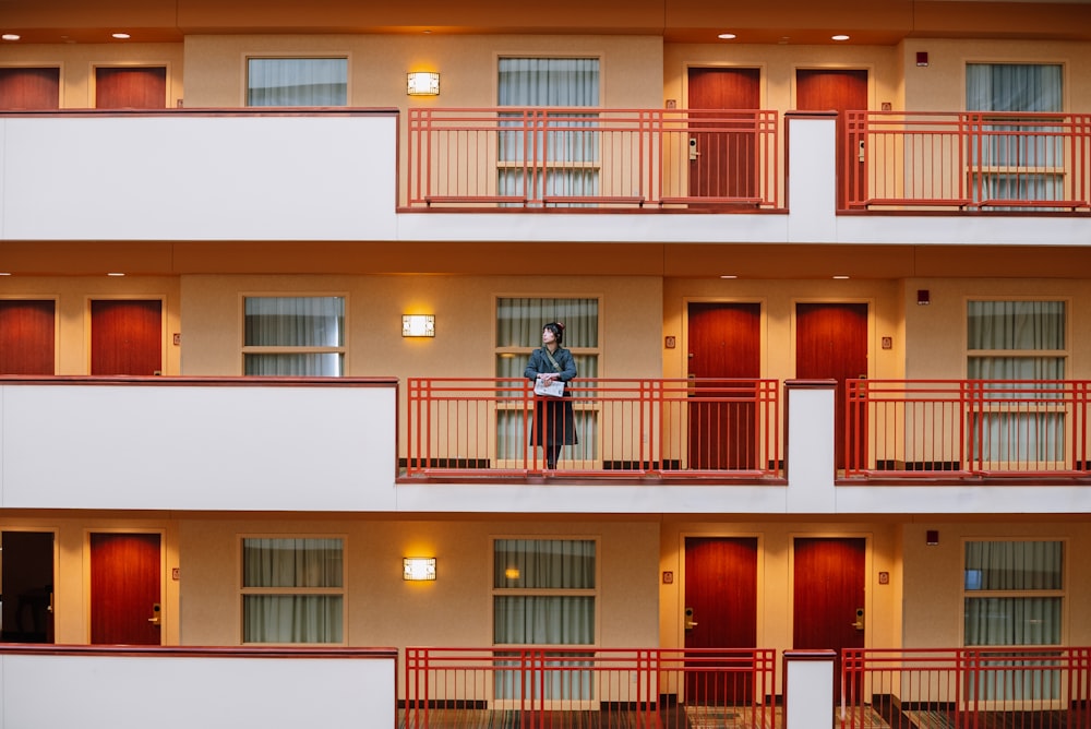 a man standing on the balcony of a hotel room