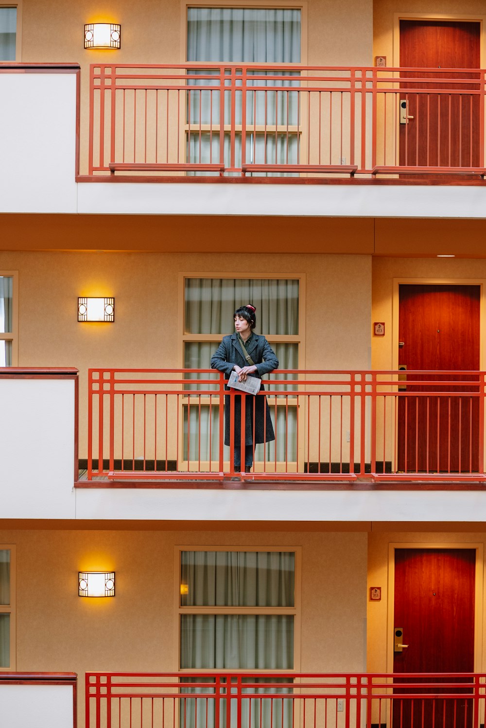 a man standing on a balcony in front of a building