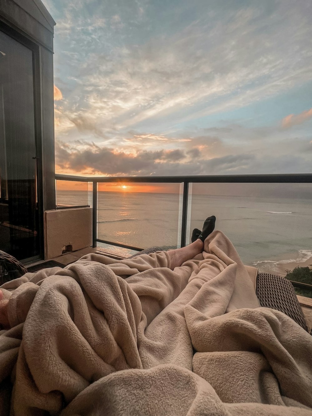 Eine Person, die in einem Bett mit Blick auf den Ozean liegt