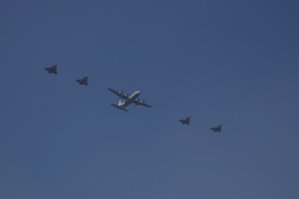 a group of fighter jets flying through a blue sky