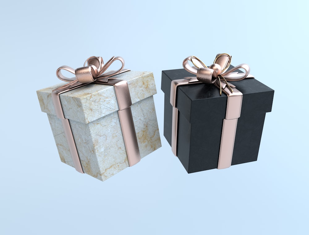 two black and white boxes with gold bows