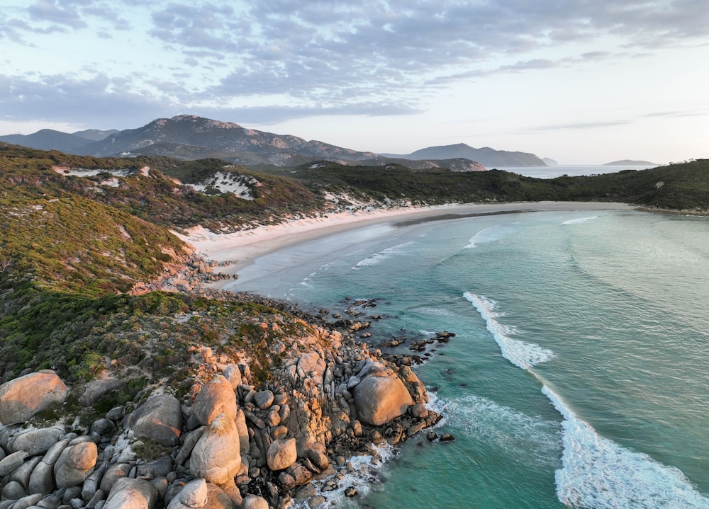 an aerial view of a rocky beach and ocean