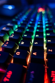 A close-up of a sleek mechanical keyboard with colorful backlighting.