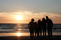 a group of people standing on top of a beach