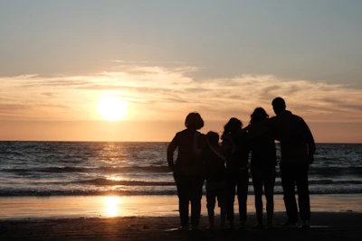 a group of people standing on top of a beach