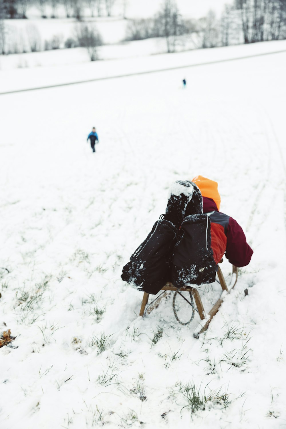 Eine Person, die einen Kinderwagen durch ein schneebedecktes Feld schiebt