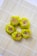 Five pieces of yellow dumplings with a filling that appears to contain minced meat and small orange carrot cubes, arranged neatly on a bamboo sushi mat. The dumplings are placed in a circular pattern, creating an aesthetically pleasing presentation.